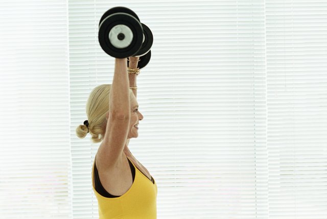 Senior woman lifting barbells in a gym