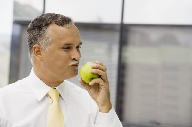 Close-up of a mature man eating an apple