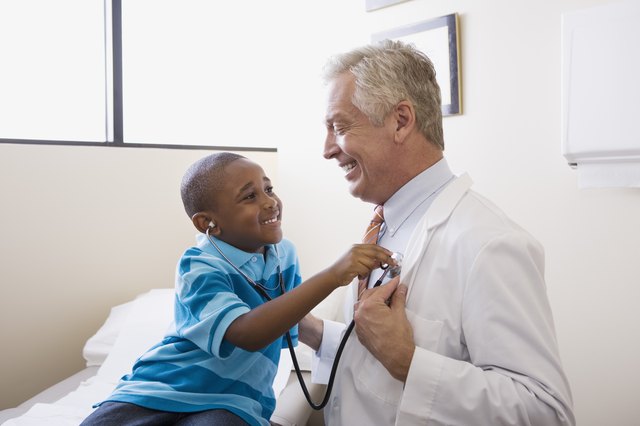 Child examining doctor with stethoscope