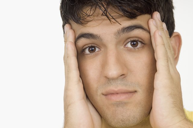 Young man holding his head, close-up