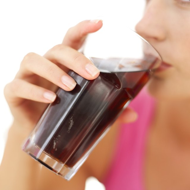 close-up of a woman drinking cola from a glass