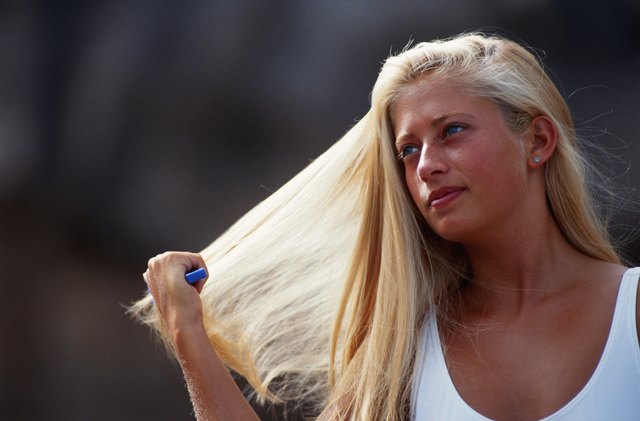 Woman combing hair, outdoors