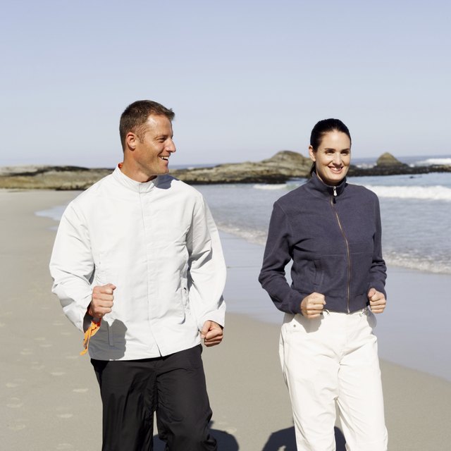 couple power walking on the beach