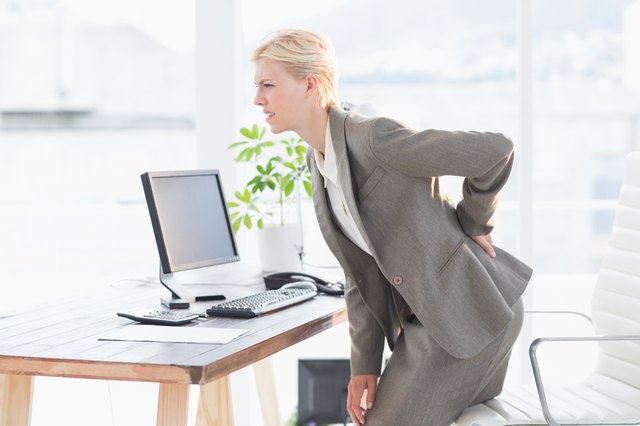 Sad businesswoman having back pain