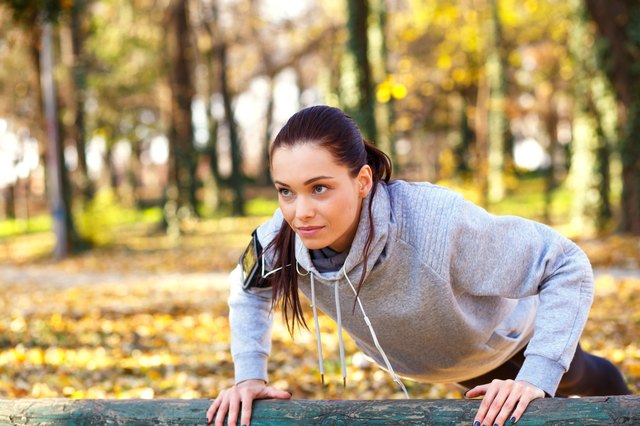 Sporty woman doing push-ups in the park
