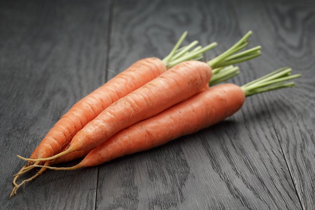 fresh organic carrots on wooden table