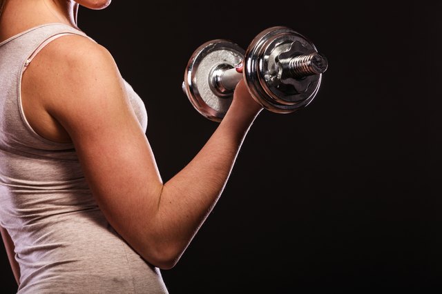 athletic woman working with heavy dumbbells