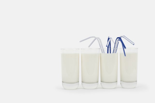Glasses of milk in a row with drinking straws