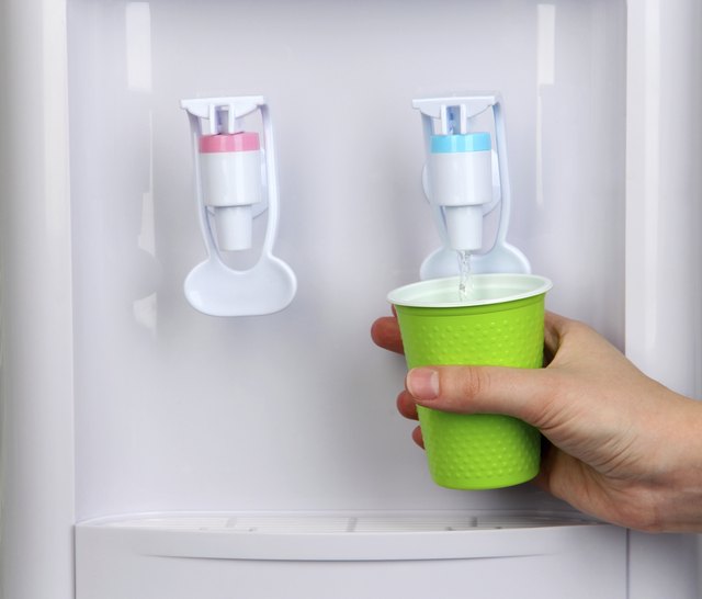 Woman filling cup at water cooler