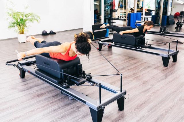 Women stretching on reformer beds