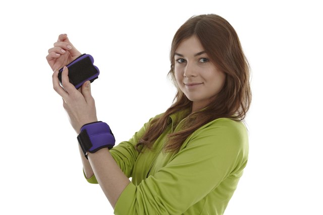 Girl with wrist weights, isolated on white.