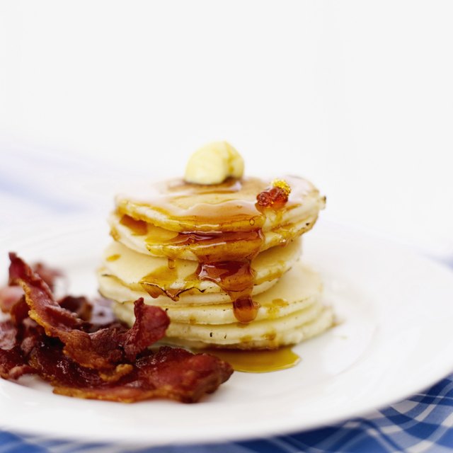 pile of pancakes served with butter and bacon rashers