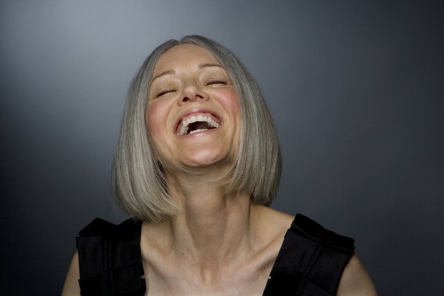 Mature woman laughing, eyes closed, close-up