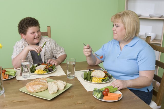 Overweight mother with overweight son having healthy meal