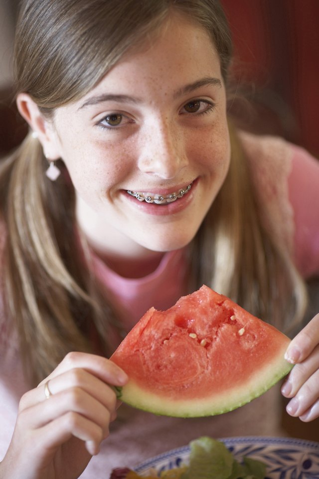 Portrait of a teenage girl holding a slice of watermelon