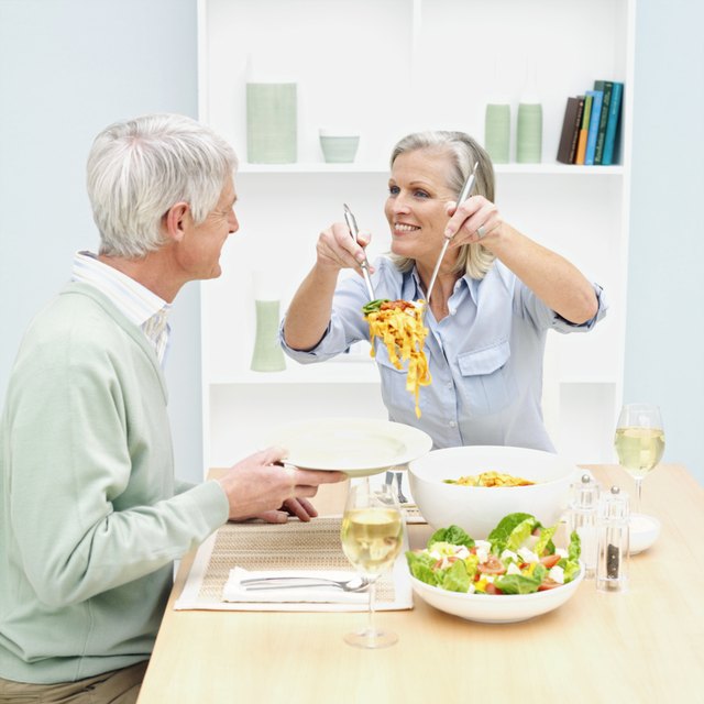 Woman serving husband food at dining table
