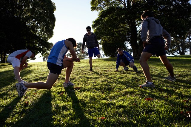 Five people stretching in park