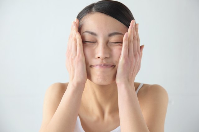 Woman putting on moisturizer