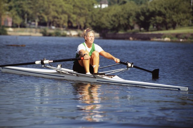 Young woman rowing scull on water