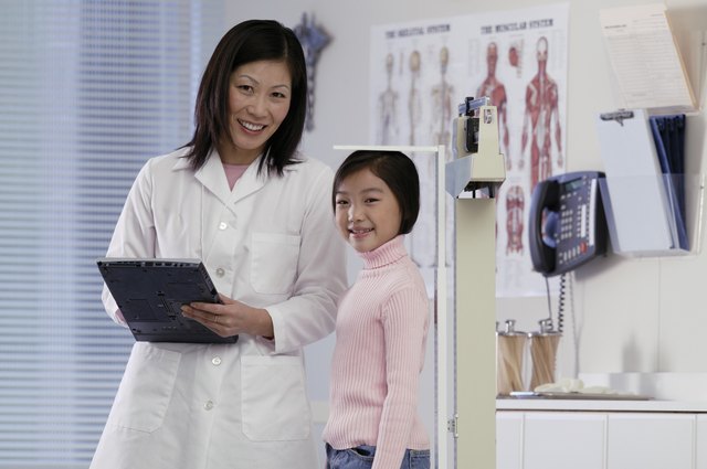Healthcare worker measuring girl's height