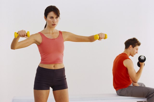 View of a young couple working out with dumbbells