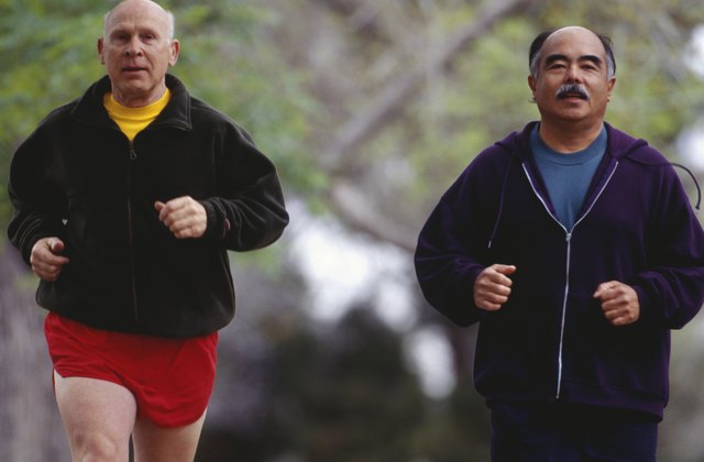 Two senior men jogging in park