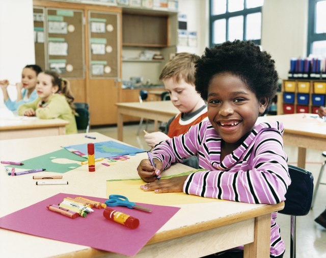 Primary School Children Sitting at Their Desks Colouring-In