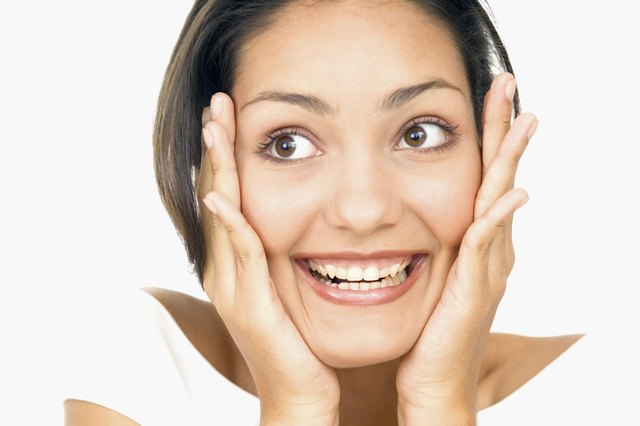 Portrait of a young woman holding her face in surprise