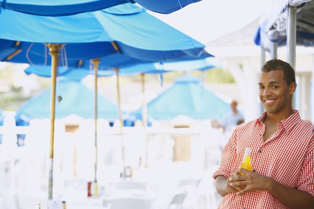 Hispanic man with drink at beach