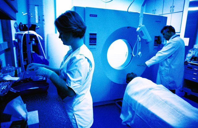 side profile of technicians readying a patient for an mri