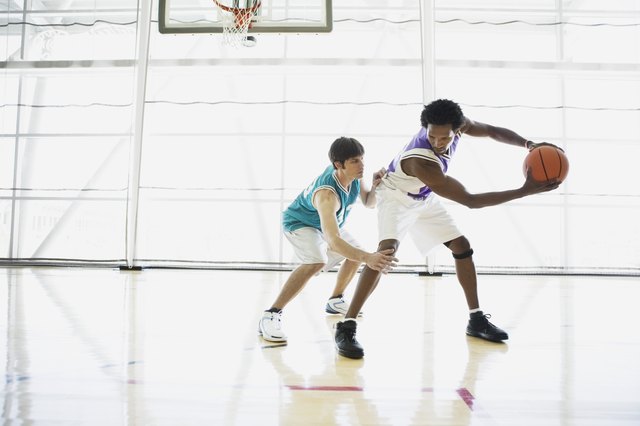 Opposing basketball players on court