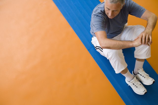 Man sitting on exercise mat