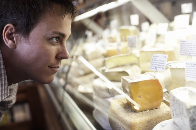 Man Looking at Cheeses
