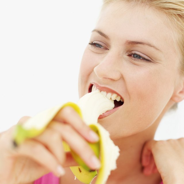 Close-up of a young woman eating a banana