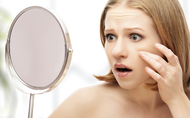 beautiful healthy woman saw in the mirror acne and wrinkles