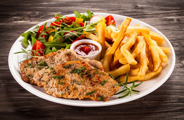 Grilled steaks, French fries and vegetables