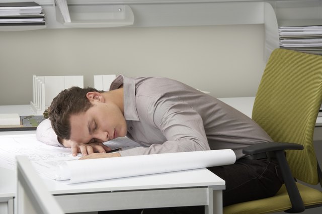 Young businessman asleep on desk