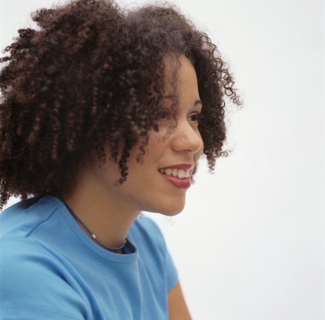 Young woman with toothy smile, posing in studio, portrait