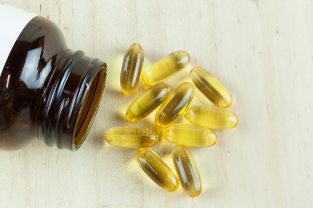 Fish Oil Arranged on wooden background with bottle laying down