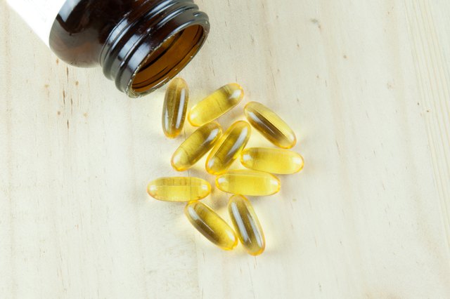 Fish Oil Arranged on wooden background with bottle laying down