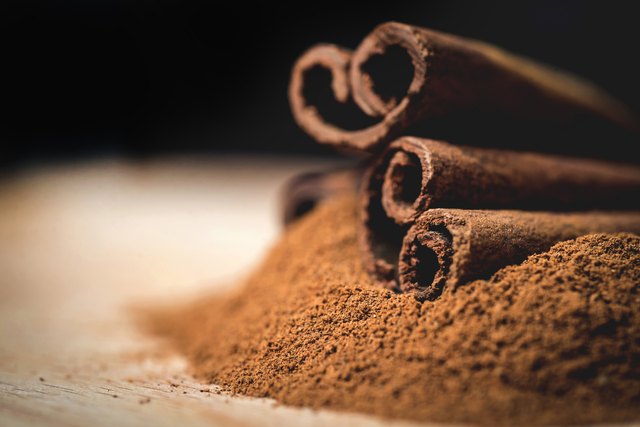 Cinnamon sticks with cinnamon powder on wooden background, Selective focus