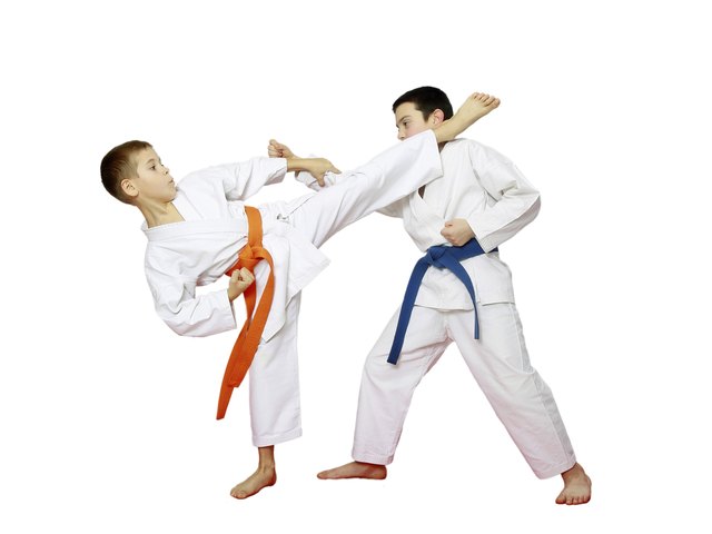 Two athletes are doing paired karate exercises