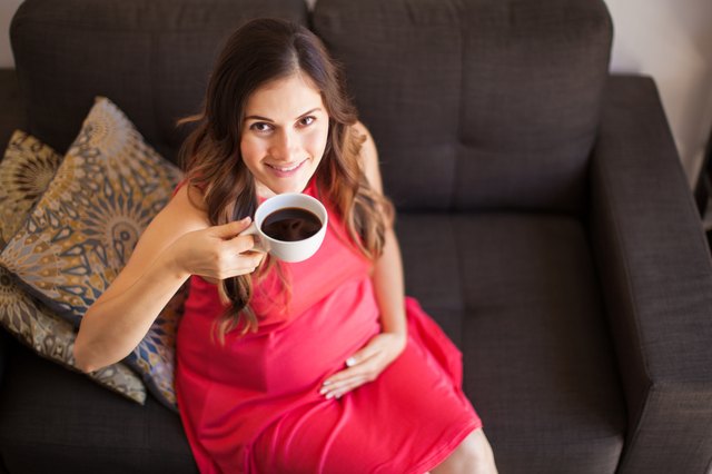 Happy pregnant woman with coffee