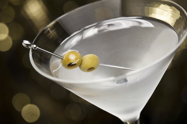 Vodka Martini with olive garnish in front of a gold