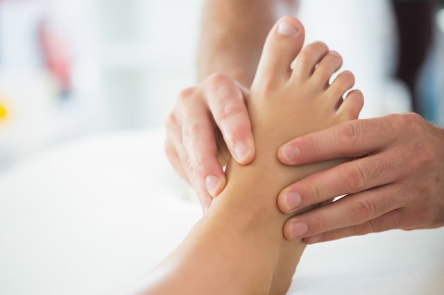 Close up of physiotherapist massaging patients foot