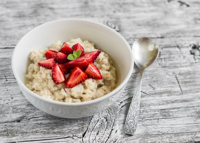 oatmeal with honey and strawberries in a white bowl