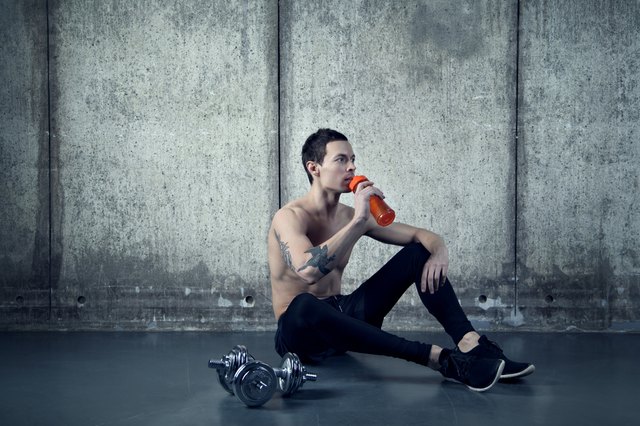 Active man with water botle and dumbbell
