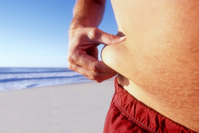 Man pinching fat on waist, mid section, close-up