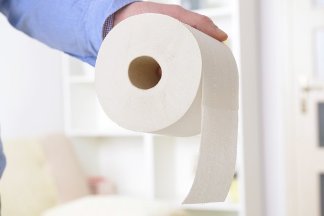 Hand holding toilet paper