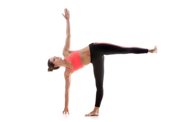 Sporty yoga girl on white background in ardha chandrasana (Half Moon Pose)